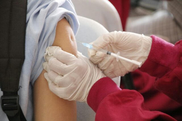 a student is being injected with a vaccine